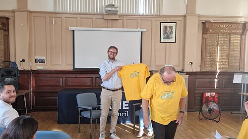 Freddie receiving a yellow Greenway campaign t-shirt at Thame Environment Forum