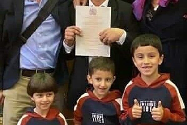 Charlie celebrating with his Syrian friend Anas and his children on receiving their citizenship