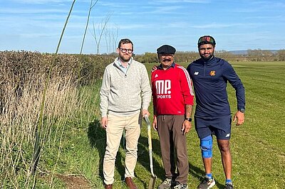 Freddie standing beside a tree with Manoj Palmer at a cricket ground