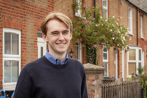 Theo in front of a row of terraced housing